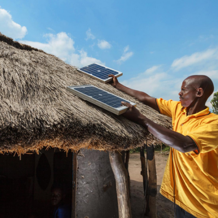 A customer installing a ReadyPay Solar Home System (SHS) -Photo by Fenix International